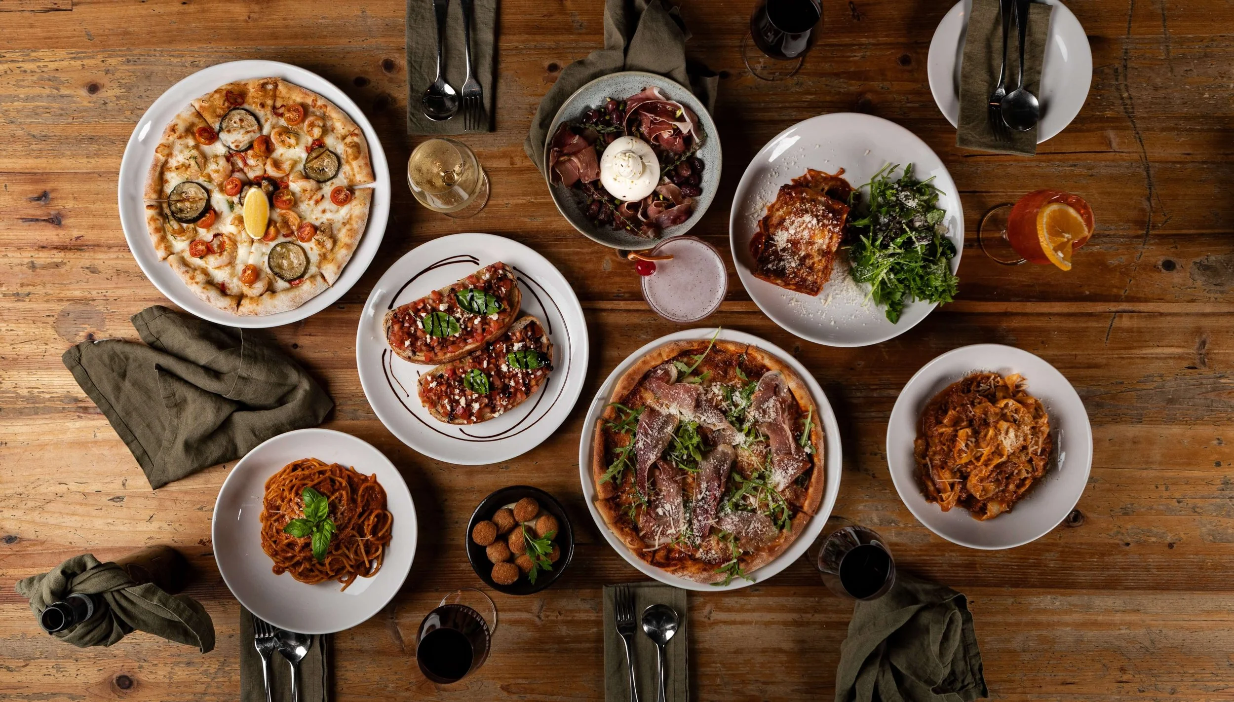 A stunning spread of authentic Italian dishes featuring fresh pasta, wood-fired pizzas, and artisan charcuterie